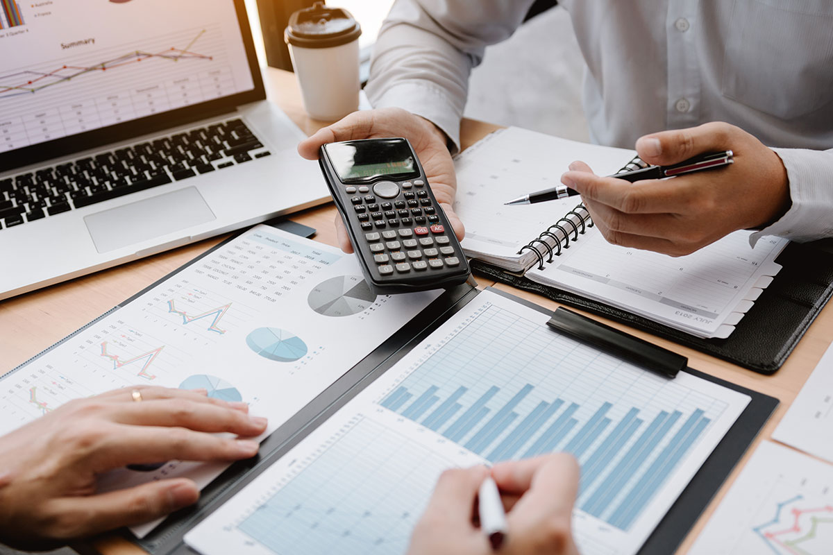 Profesionales analizando datos financieros y de marketing con gráficos y calculadora