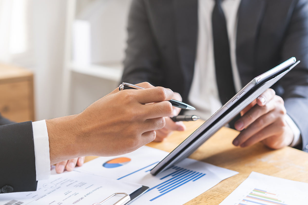 Ejecutivos revisando gráficos y métricas digitales en una tablet