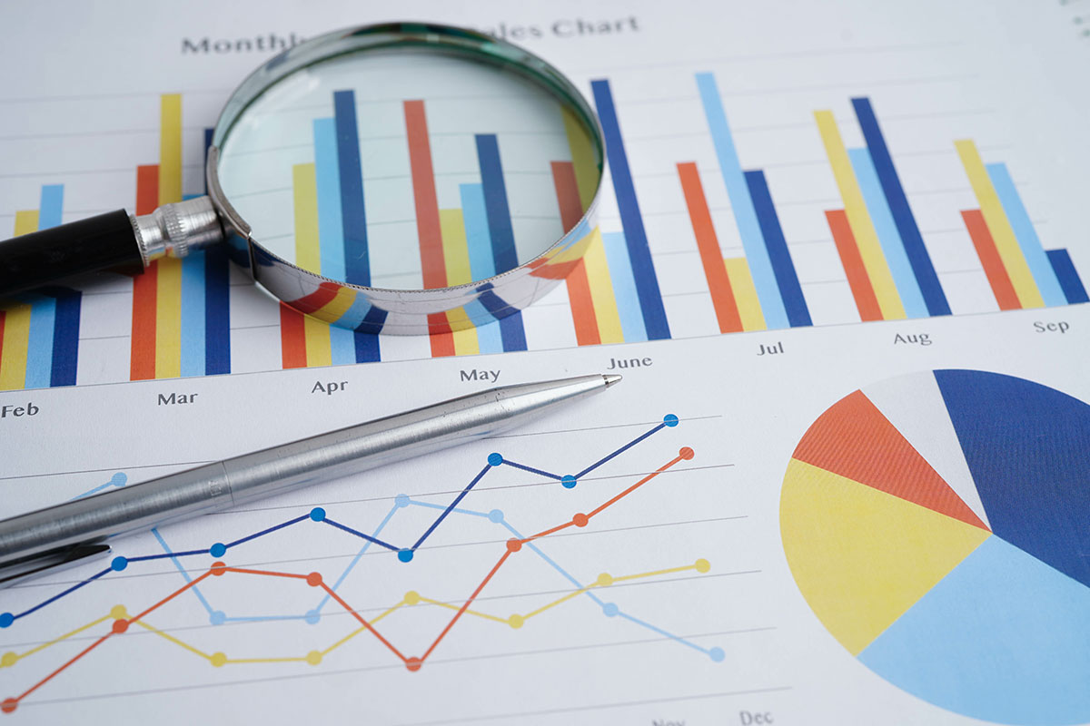 Análisis de datos y gráficos de marketing digital con lupa y bolígrafo